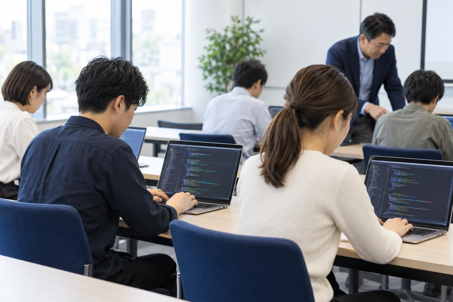 受講者がそれぞれのPCでプログラミングに取り組んでいる研修風景